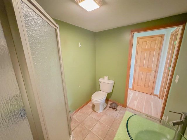 174 Rockyford Rd, Sublette, IL 61367 - bathroom featuring toilet, tile patterned flooring, a sink, baseboards, and a shower with shower door
