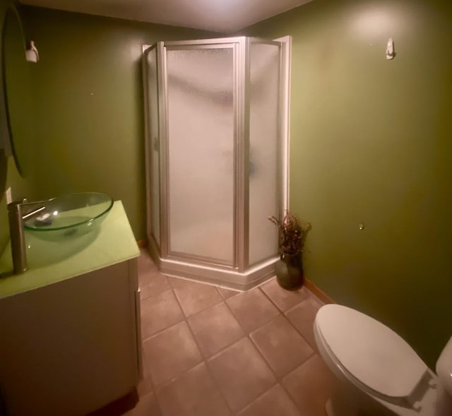 bathroom with vanity, tile patterned flooring, a shower with door, and toilet