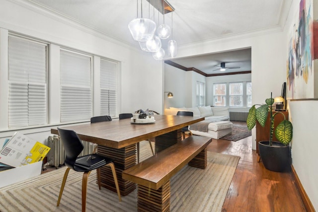 dining space with radiator heating unit, dark hardwood / wood-style floors, ceiling fan, and ornamental molding