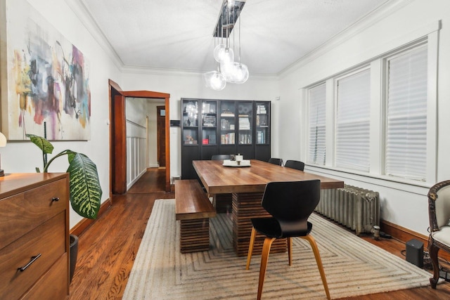 dining space featuring dark hardwood / wood-style flooring, radiator heating unit, and crown molding