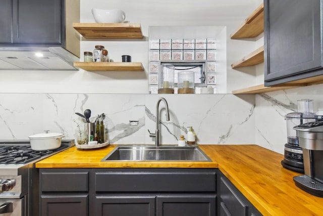 kitchen featuring wooden counters, ventilation hood, tasteful backsplash, and sink