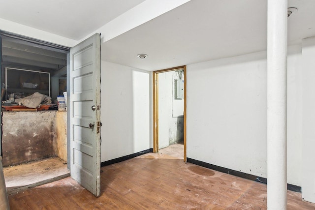 hallway with electric panel and wood-type flooring