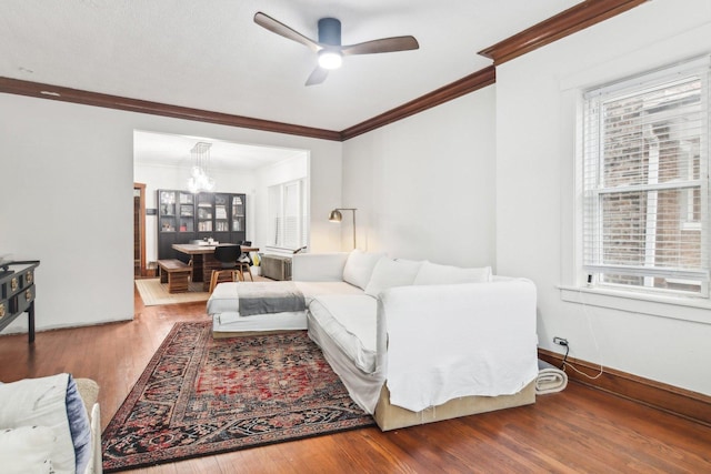 living room featuring hardwood / wood-style floors, a healthy amount of sunlight, and ceiling fan with notable chandelier