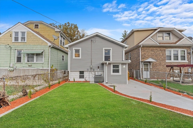 rear view of property with central air condition unit and a lawn