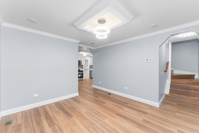 empty room with light hardwood / wood-style flooring and ornamental molding