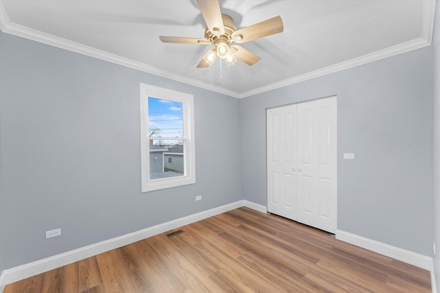 unfurnished bedroom with ceiling fan, a closet, light hardwood / wood-style flooring, and ornamental molding