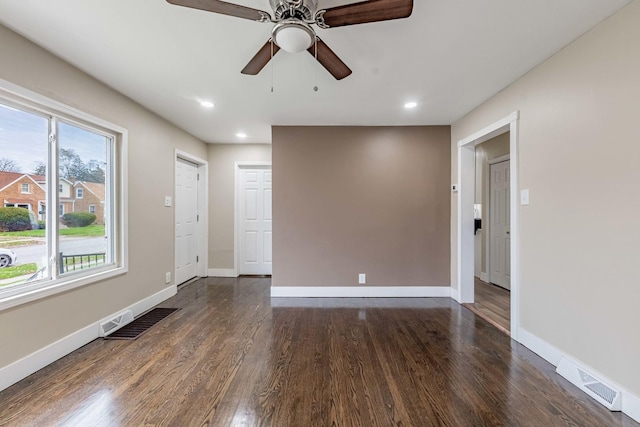 empty room with ceiling fan and dark wood-type flooring