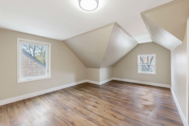 bonus room with vaulted ceiling and light hardwood / wood-style flooring