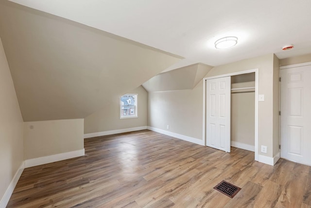 bonus room with wood-type flooring and lofted ceiling