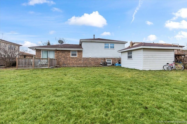 rear view of property featuring central air condition unit, a wooden deck, and a lawn