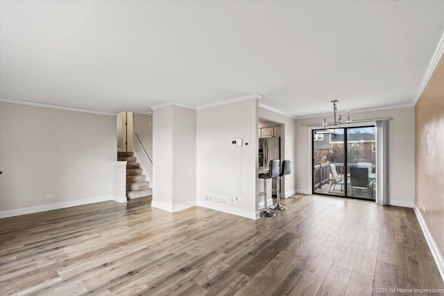 unfurnished living room featuring a chandelier, crown molding, and light hardwood / wood-style floors