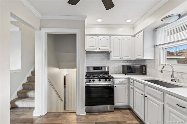 kitchen with sink, decorative backsplash, dark hardwood / wood-style flooring, white cabinetry, and stainless steel range with gas stovetop