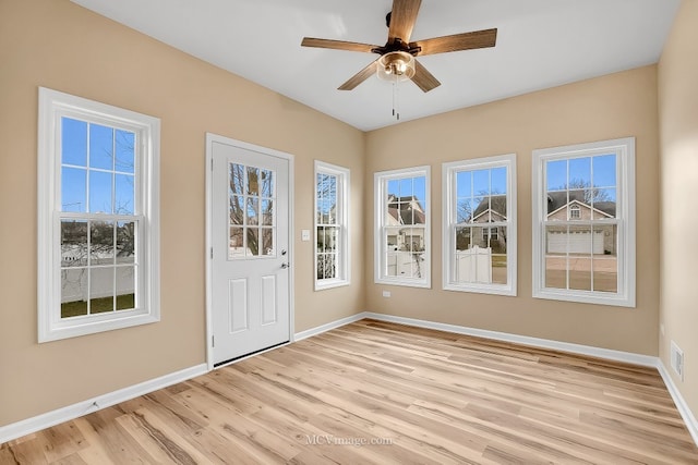 unfurnished sunroom featuring ceiling fan