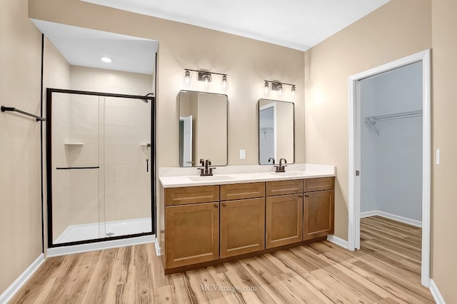 bathroom featuring vanity, wood-type flooring, and a shower with shower door