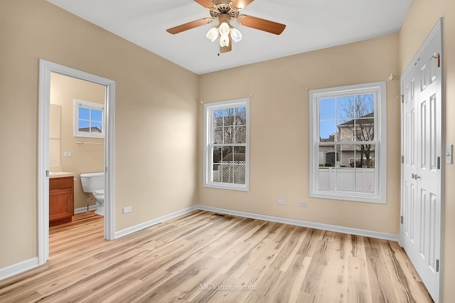 interior space featuring light wood-type flooring, ensuite bathroom, and ceiling fan