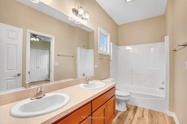 full bathroom featuring ceiling fan, hardwood / wood-style floors, toilet, shower / tub combination, and vanity