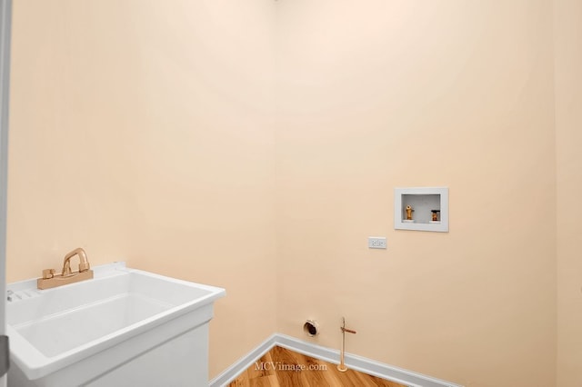 washroom with wood-type flooring, sink, and hookup for a washing machine