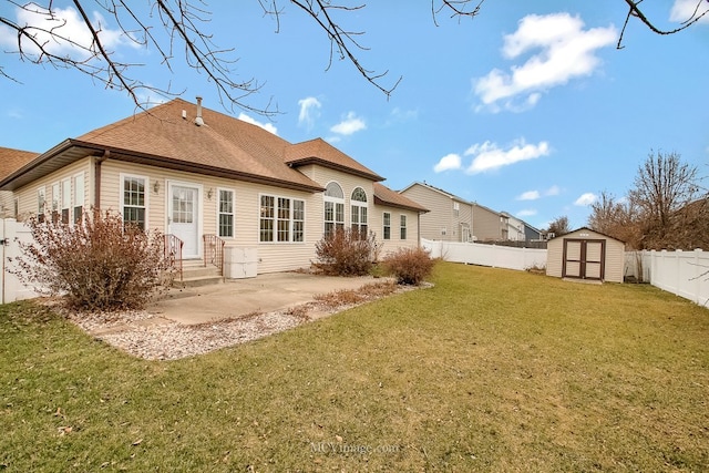 rear view of house featuring a yard, a patio, and a storage shed