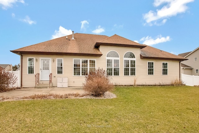 back of property featuring a lawn and a patio