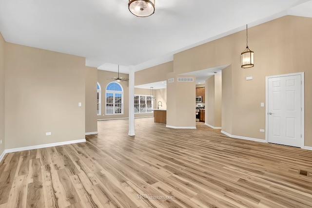 unfurnished living room with ceiling fan, light hardwood / wood-style flooring, and sink