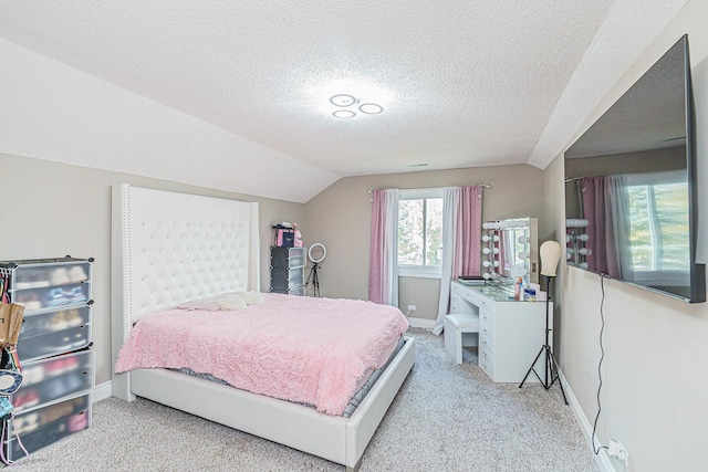 bedroom featuring a textured ceiling, light colored carpet, and lofted ceiling