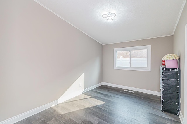 unfurnished room featuring a textured ceiling, dark hardwood / wood-style floors, and crown molding