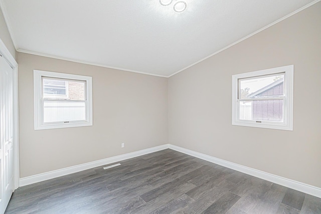 unfurnished room with lofted ceiling, a textured ceiling, crown molding, and dark wood-type flooring