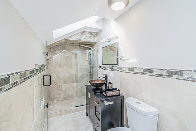 bathroom with an enclosed shower, vanity, tile walls, toilet, and lofted ceiling