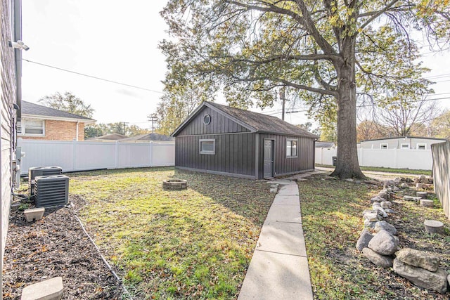 view of yard featuring central AC, an outdoor fire pit, and an outdoor structure