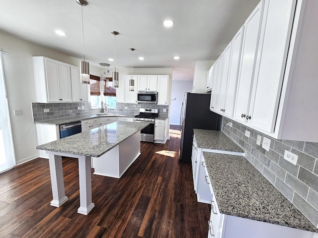 kitchen with white cabinets, a center island, sink, and stainless steel appliances