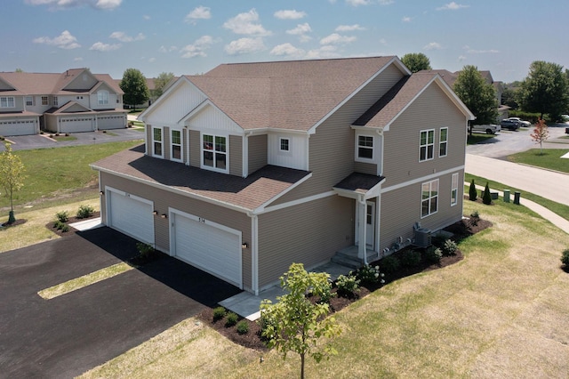 view of front of property with a garage, a front lawn, and central air condition unit