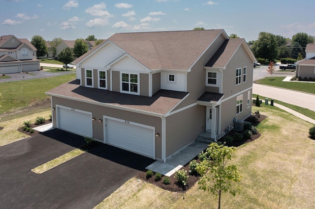 view of front of house with a front lawn, a garage, and cooling unit