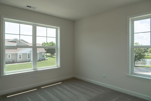 carpeted spare room featuring a water view