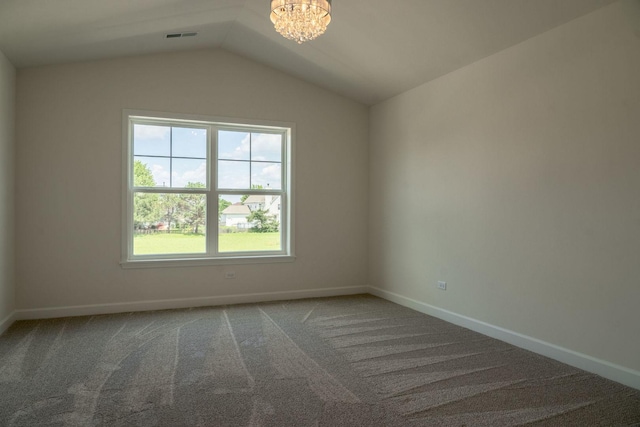 spare room featuring carpet flooring, a notable chandelier, and vaulted ceiling