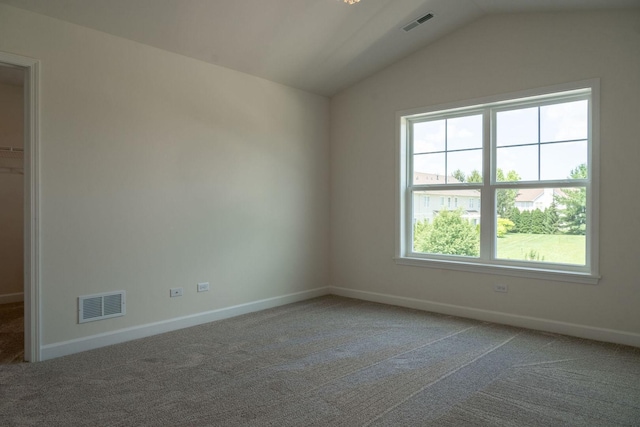 empty room featuring carpet flooring and lofted ceiling