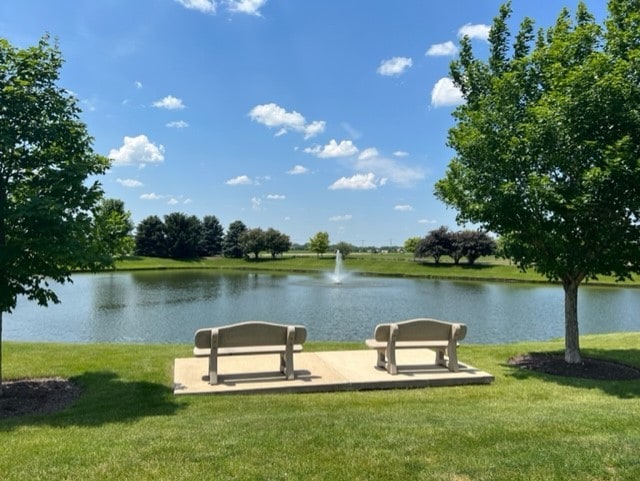 view of community featuring a lawn and a water view