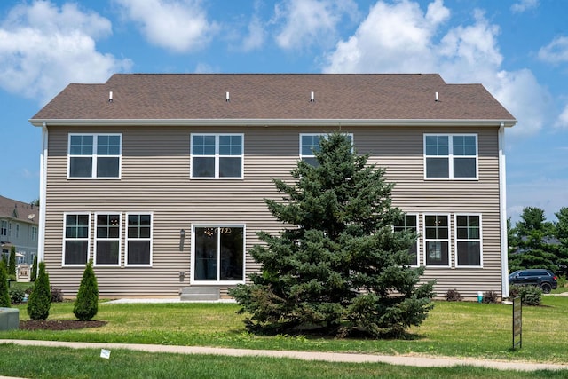 rear view of property featuring a lawn