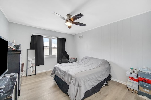 bedroom with light hardwood / wood-style floors, ceiling fan, and crown molding