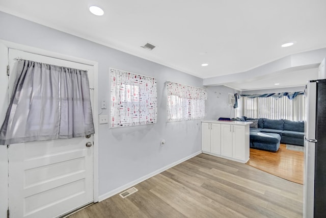 kitchen featuring white cabinets, light hardwood / wood-style floors, and fridge