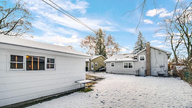 view of snow covered back of property