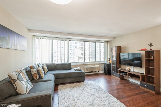 living room with dark hardwood / wood-style flooring and an AC wall unit