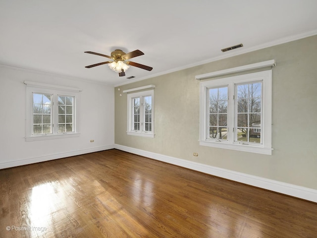 empty room with a wealth of natural light, hardwood / wood-style floors, ceiling fan, and ornamental molding