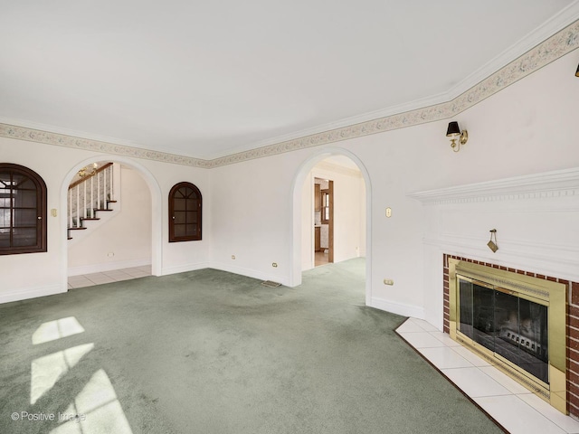 unfurnished living room with ornamental molding, light colored carpet, and a brick fireplace