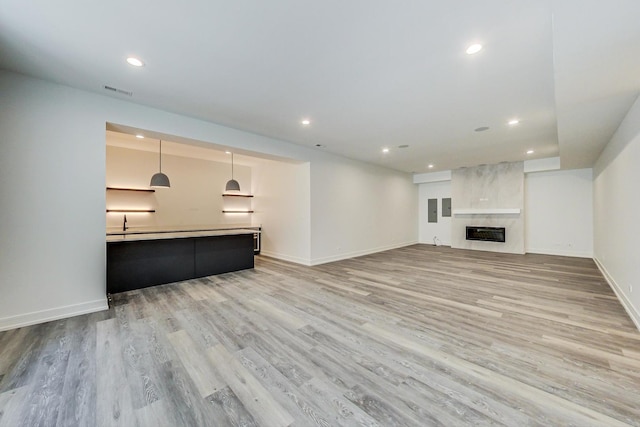 unfurnished living room with light wood-type flooring and a premium fireplace