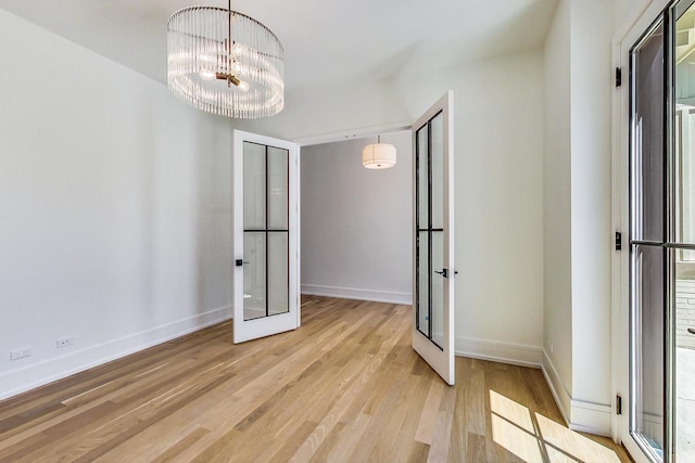 interior space featuring a chandelier, french doors, and light hardwood / wood-style floors