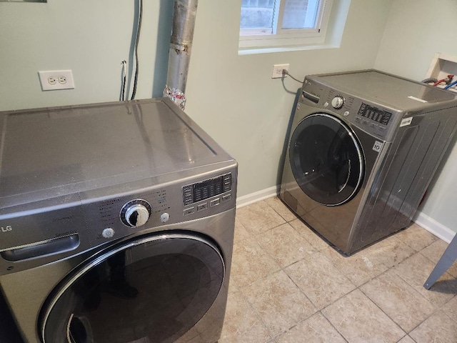 laundry room featuring light tile patterned floors and separate washer and dryer