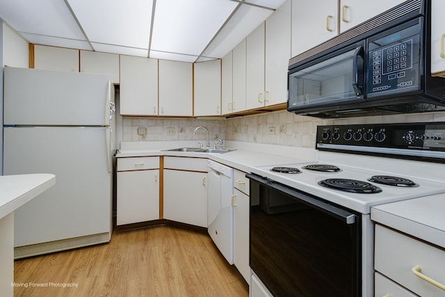 kitchen featuring white cabinets, light wood-type flooring, white appliances, and sink