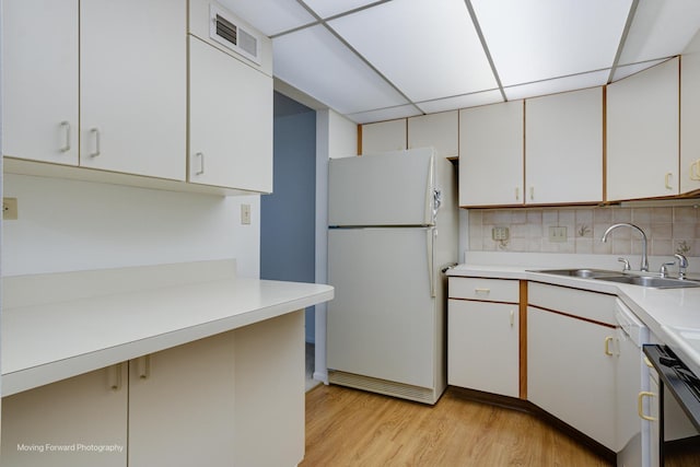 kitchen with white cabinetry, sink, a drop ceiling, white fridge, and decorative backsplash