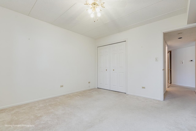 unfurnished bedroom featuring light colored carpet, a closet, and ceiling fan