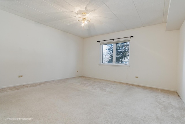 spare room featuring light carpet and ceiling fan